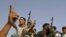 Un combatiente anti-Gadhafi coloca una bandera del reino durante el sitio a Bani Walid.
