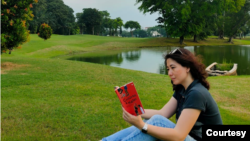 Victoria Tunggono, Penulis Buku “Child Free and Happy”, menikmati suasana tenang di sebuah taman sambil membaca buku. (Foto: pribadi)