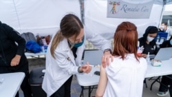 A woman receives a dose vaccine against the coronavirus disease (COVID-19) in the Thai CDC Free Covid-19 Vaccination Clinic at East Hollywood Farmer’s Market, Los Angeles, CA.