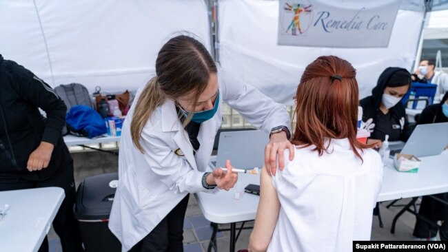 A woman receives a dose vaccine against the coronavirus disease (COVID-19) in the Thai CDC Free Covid-19 Vaccination Clinic at East Hollywood Farmer’s Market, Los Angeles, CA.