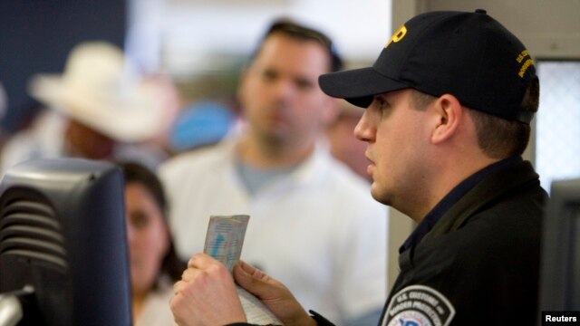 Un agente de aduanas y protección fronteriza revisa un pasaporte en el punto de cruce de San Ysidro, California. Foto de Archivo. La agencia de Aduanas y Protección Fronteriza ofrece ahora servicios en español en su página web y a través de un número telefónico.