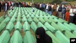 Bosnian people pray near coffins of Srebrenica victims, during amass funeral in Potocari 120 km northeast of Sarajevo, Bosnia (File Photo - July 11, 2010)