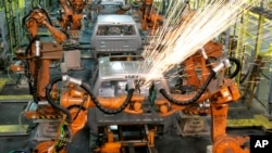 In this Sept. 12, 2008 file photo, assembly line robots weld the front cab of a Chrysler pickup truck being assembled in Warren, Michigan. 