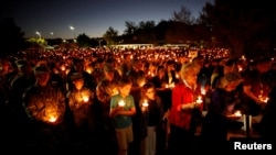 People hold candles during a memorial service for Charleston Hartfield, an off-duty Las Vegas police officer who was killed during the Route 91 music festival mass shooting, in Las Vegas, Nevada, Oct. 5, 2017.