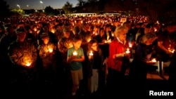 People hold candles during a memorial service for Charleston Hartfield, an off-duty Las Vegas police officer who was killed during the mass shooting, in Las Vegas, Nevada, Oct. 5, 2017.