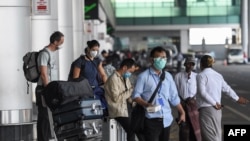 抵達緬甸首都仰光國際機場的乘客戴著防護性口罩。資料照（2020年1月31日）。