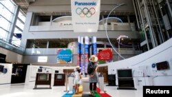 Para pengunjung menyaksikan pameran yang menunjukkan sejarah kemitraan antara Panasonic Corp. dan Olimpiade di pusat Panasonic di Tokyo, 6 Agustus 2014. 