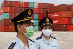 FILE - Vietnamese customs officers wearing protective masks patrol at a containers port, amid the spread of the coronavirus disease (COVID-19), in Quang Ninh province, Vietnam, Aug. 13, 2020.