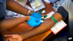 FILE - A clinical trial patient receives a dose of AstraZeneca test vaccine at the University of Witwatersrand facility in Soweto, South Africa, Nov. 30, 2020. 