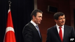 Secretary-General of NATO Anders Fogh Rasmussen, left, and Turkey's Foreign Minister Ahmet Davutoglu shake hands after a joint news conference in Ankara, Turkey, February 17, 2012.