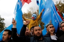 FILE - A masked Uighur boy takes part in a protest against China, at the courtyard of Fatih Mosque, a common meeting place for pro-Islamist demonstrators in Istanbul, Turkey, Nov. 6, 2018.