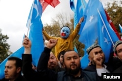 FILE - A masked Uighur boy takes part in a protest against China, at the courtyard of Fatih Mosque, a common meeting place for pro-Islamist demonstrators in Istanbul, Turkey, Nov. 6, 2018.