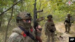 FILE - In this photo from video released by the Russian Defense Ministry on Sept. 23, 2024, Russian soldiers patrol a trail in the Russian-Ukrainian border area in Russia's Kursk region. (Russian Defense Ministry Press Service via AP)