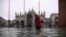 Seorang wanita melintasi alun-alun St. Mark yang dibanjiri oleh Basilika Santo Markus setelah ketinggian air pasang semalam "Alta Acqua", awal 13 November 2019 di Venesia. (Foto: AFP)