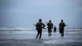World War II reenactors walk on Omaha Beach in Saint-Laurent-sur-Mer, Normandy, France, Tuesday, June 6, 2023. Nearly 160,000 Allied troops landed on the shores of Normandy at dawn on June 6, 1944.
