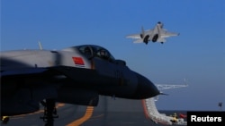 FILE - A live-fire drill using a Chinese aircraft carrier and jets is carried out in the Bohai sea, China.