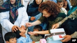 Ellyn Ogden, USAID's worldwide polio eradication coordinator, immunizes a child during a festive kick-off event for a polio vaccination campaign in Kabul, Afghanistan.