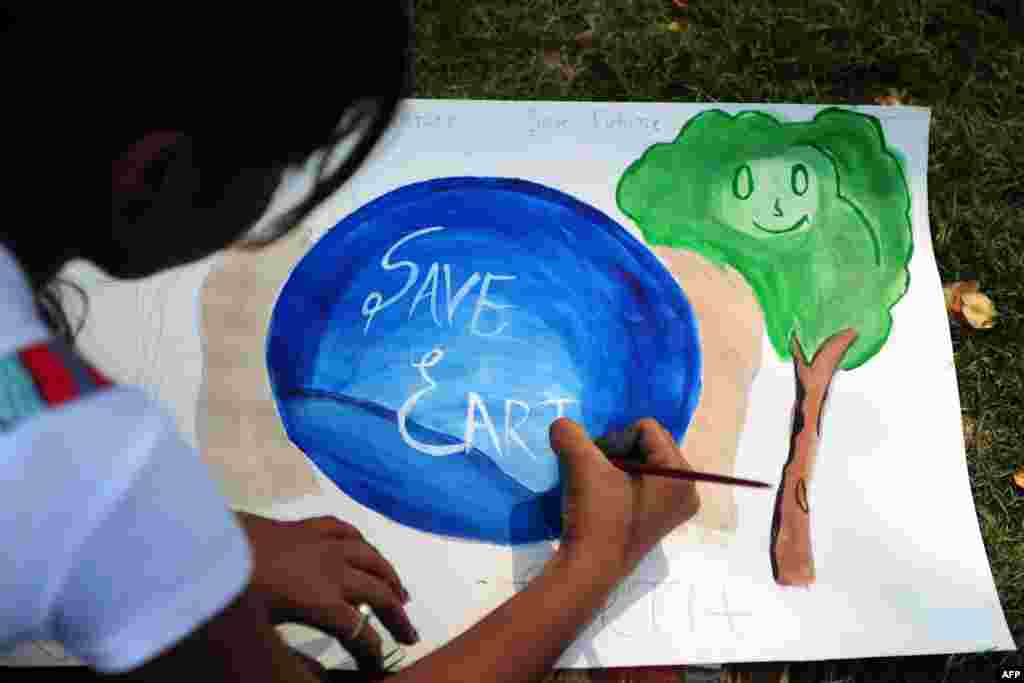 An Indian child paints during an awareness event organized by the Aakalpan Artist Society commemorating Earth Day in Allahabad, April 22, 2013.