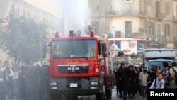 Riot police fire a water cannon to disperse people protesting against a new law restricting demonstrations, in downtown Cairo, Nov. 26, 2013. 