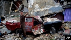 Men work to remove rubble from a car after a home collapsed on it during a tornado in Regla, Cuba, Jan. 28, 2019. 