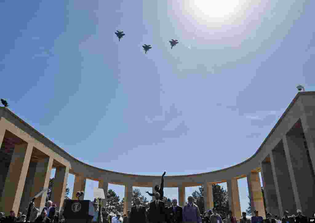 U.S. President Barack Obama and French President Francois Hollande stand with veterans during a fly over of the Normandy American Cemetery, at Omaha Beach in Colleville sur Mer in Normandy, France, June 6, 2014.