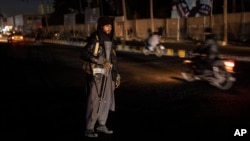 FILE - A Taliban fighter stands at a checkpoint in Herat, Afghanistan, Nov. 28, 2021. 