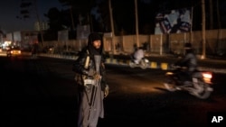 FILE - A Taliban fighter stands at a check point in Herat, Afghanistan, Nov. 28, 2021. 