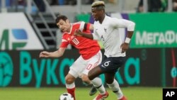 France's Paul Pogba, right, and Russia's Fyodor Smolov during the international friendly soccer match between Russia and France in St.Petersburg, Russia, Tuesday, March 27, 2018. (AP Photo/Dmitri Lovetsky)