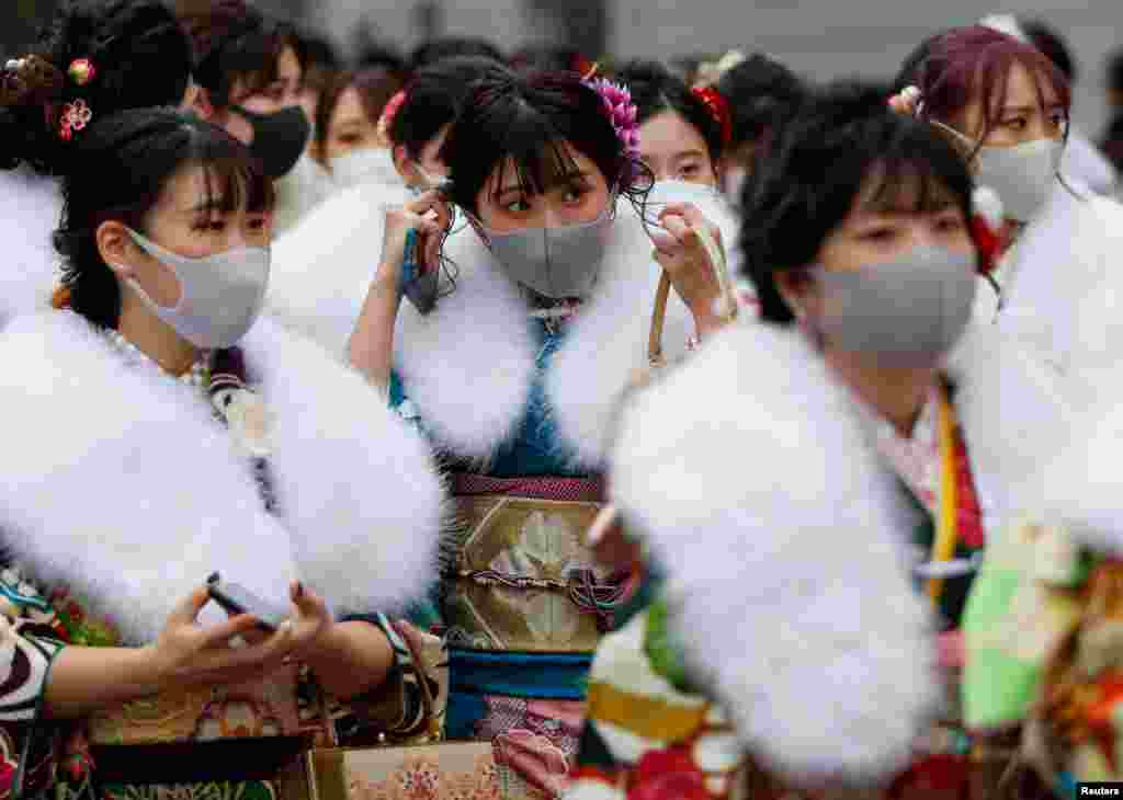 Kimono-clad youth wearing protective face masks leave their Coming of Age Day celebration ceremony at Yokohama Arena in Yokohama, south of Tokyo, Japan, during the government declared the second state of emergency for the capital and some prefectures, amid the COVID-19 pandemic.