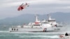 FILE - Taiwan Coast Guard ships and a helicopter take part in a drill at a harbor in New Taipei City, Taiwan, May 4, 2019.