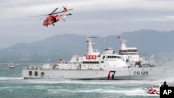 FILE - Taiwan Coast Guard ships and a helicopter take part in a drill at a harbor in New Taipei City, Taiwan, May 4, 2019.