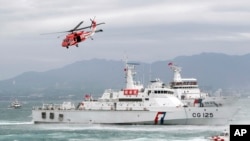 FILE - Taiwan Coast Guard ships and a helicopter take part in a drill at a harbor in New Taipei City, Taiwan, May 4, 2019.