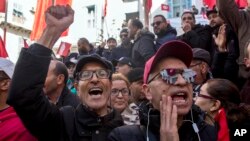 FILE: In this photo taken January 17, 2019, Tunisian workers stage a protest in front of the national union headquarters in the capital Tunis, to demand higher pay in a standoff with the government.