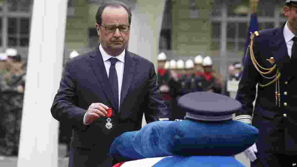Le président français François Hollande remet la Légion d'honneur à titre posthume à Xavier Jugelé, le policier abattu sur les Champs-Élysées, lors d'une cérémonie à la Préfecture de police de Paris, le mardi 25 avril 2017.