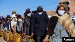 Las personas hacen fila para llenar sus balones de gas en El Alto, Bolivia, debido a una escasez del producto provocada por obreros del sector energético que dejaron de trabajar tras contraer COVID-19.
