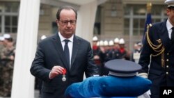 Le président français François Hollande décore à titre posthume l'officier de police tué Xavier Jugelé abattu sur les Champs-Élysée, au siège de la police de Paris, France, 25 avril 2017.