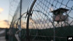 ແສງຕາເວັນຂອງອາລຸນໃໝ່ ຢູ່ດ້ານຫຼັງຂອງສະຖານທີ່ຄຸມຂັງ Guantanamo ຢູ່ໃນຖານທັບກອງທັບເຮືອ ສະຫະລັດ ທີ່ອ່າວ Guantanamo Bay ຂອງປະເທດ Cuba.
