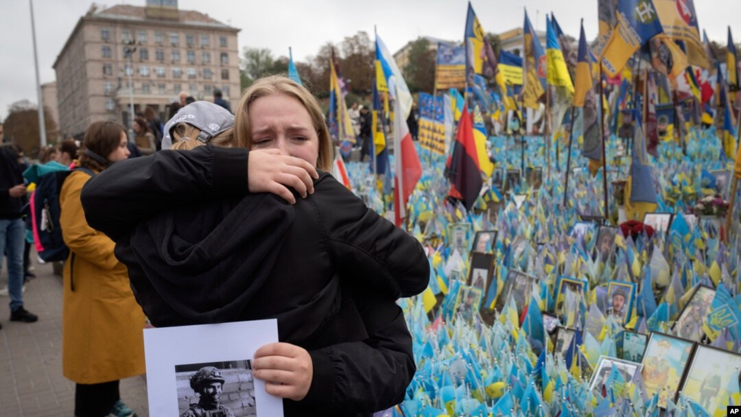 Луѓето реагираат за време на минута молк на национално ниво во спомен на загинатите војници кои ја бранеа својата татковина од војната со Русија, на Денот на бранителите на импровизираниот воен споменик на плоштадот на независноста во Киев, Украина, 1 октомври 2024 година.