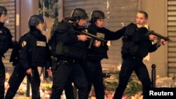 Police react to a suspicious vehicle near Le Carillon restaurant following a series of deadly attacks in Paris, Nov. 15, 2015. 