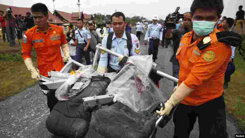Des pièces de l'avion d'AirAsie Vol 8501, récupérées de la mer de Java, sont transportés après qu'ils ont été déchargées d'un hélicoptère de l'US Navy à l'aéroport de Pangkalan Bun, Kalimantan Central, l'Indonésie, le 5 janvier 2015.