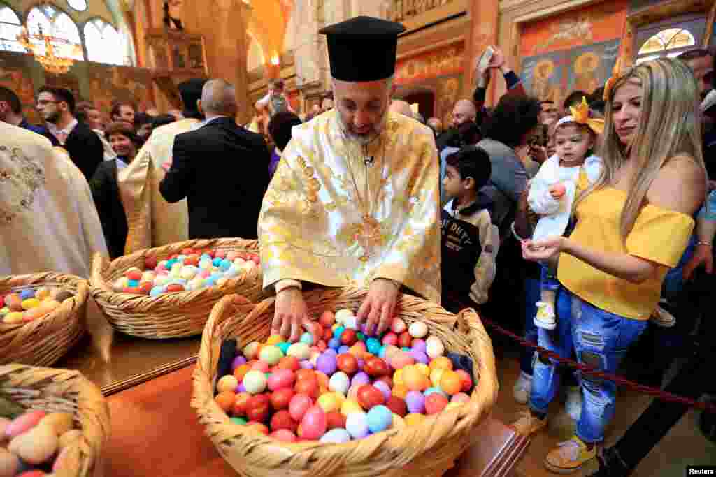 Ліванські християнські священники роздають фарбовані яйця після пасхального богослужіння в Георгіївській церкві в центрі Бейрута, Ліван, 16 квітня 2017 року.