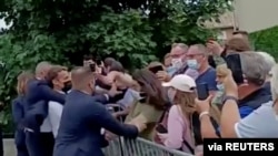 French President Emmanuel Macron is protected by a security officer after getting slapped by a member of the public during a visit to Tain-L'Hermitage, France, in this still image taken from video on June 8, 2021. (BFMTV/ReutersTV via Reuters) 