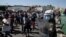 Asylum seekers take part in a rally as riot police block the road near Mytilene town, on the island of Lesbos, Greece, Sept. 11, 2020, after fires destroyed the notoriously overcrowded Moria camp, leaving thousands without shelter.