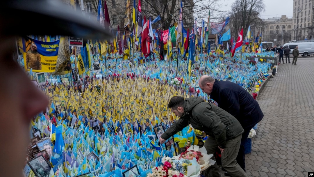 Ukrainian President Volodymyr Zelenskyy, left, and German Chancellor Olaf Scholz attend a ceremony of honoring fallen soldiers near the People's Memorial of National Memory in Kyiv, Dec.2, 2024.
