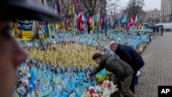 Ukrainian President Volodymyr Zelenskyy, left, and German Chancellor Olaf Scholz attend a ceremony of honoring fallen soldiers near the People's Memorial of National Memory in Kyiv, Dec.2, 2024.