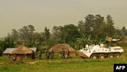 Une patrouille bangladaise de la Mission de stabilisation de l'Organisation des Nations Unies en République démocratique du Congo (MONUSCO) passe près des soldats congolais à Gety, près de Kaswara, dans la province de l'Ituri, le 26 janvier 2016.