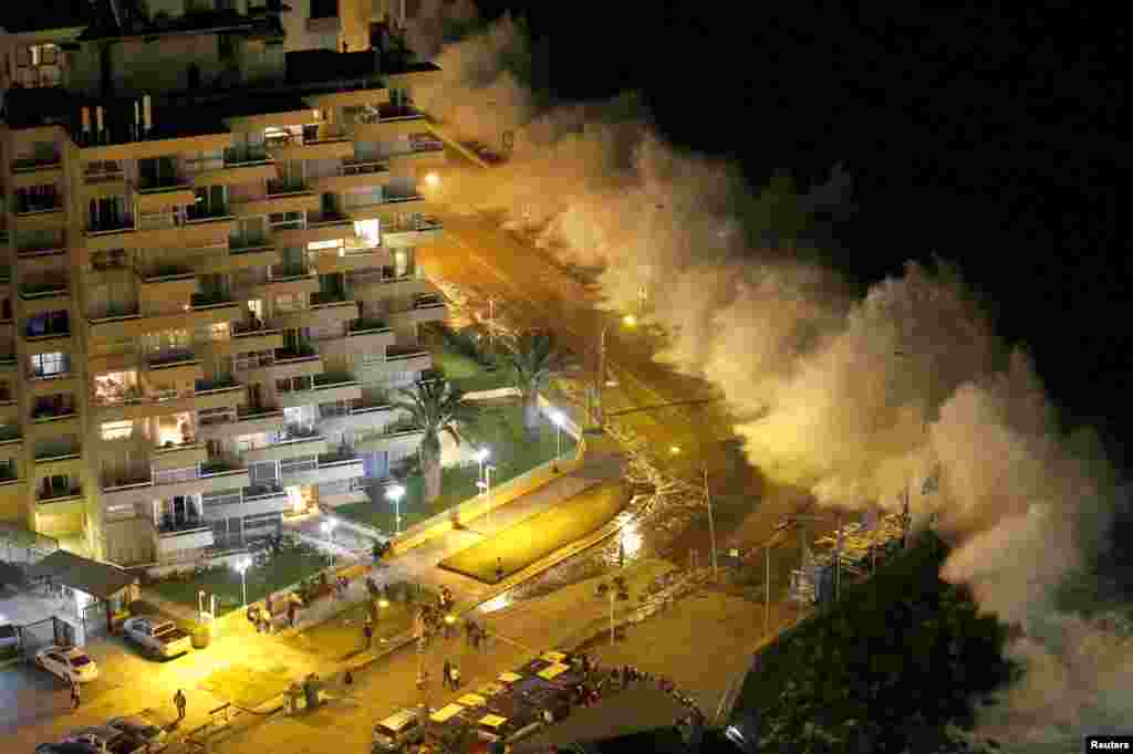 Tourists watch high waves of the Pacific Ocean pounding the coast in Vina del Mar city, Chile.