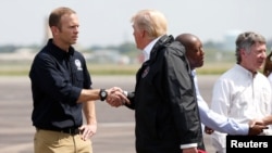 美国总统唐纳德·川普在抵达德克萨斯州的艾灵顿菲尔德联合基地后会见联邦紧急事务管理署署长布罗克·朗（2017年9月2日）。