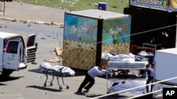 Investigators load bodies from the scene of a mass shooting at a music festival near the Mandalay Bay resort and casino on the Las Vegas Strip on Monday, Oct. 2, 2017, in Las Vegas. 