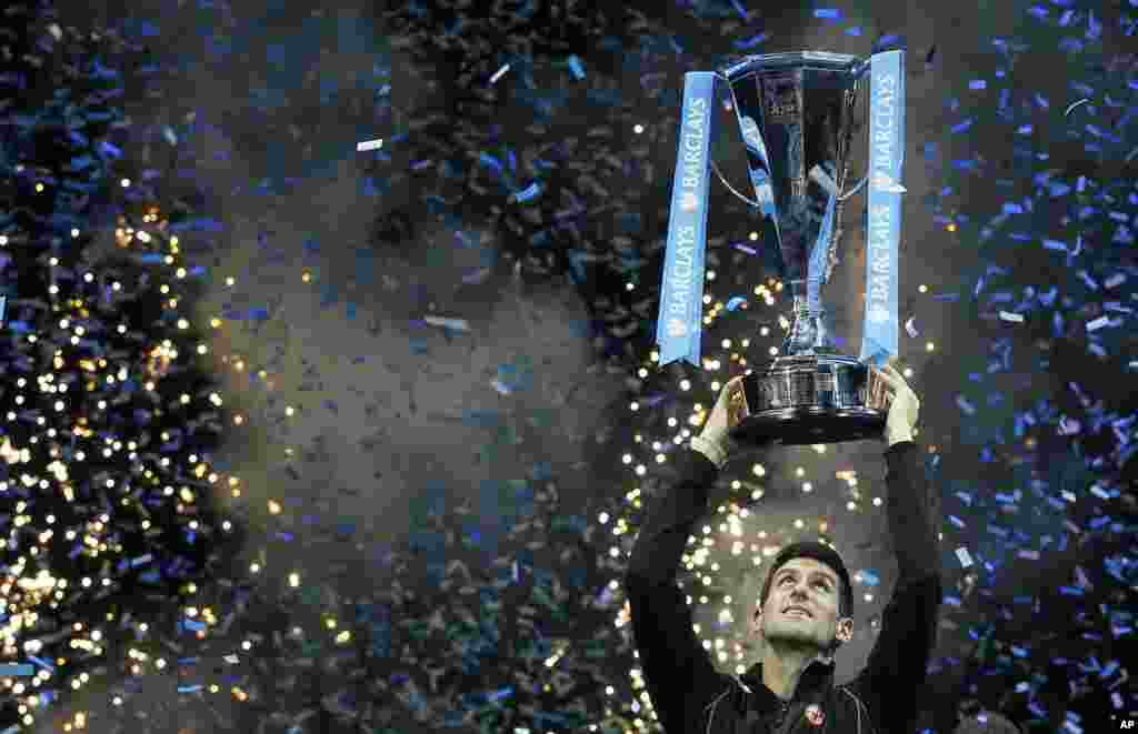Novak Djokovic of Serbia holds up the ATP World Tour Finals tennis trophy after defeating Rafael Nadal of Spain at the O2 Arena in London, Nov. 11, 2013.